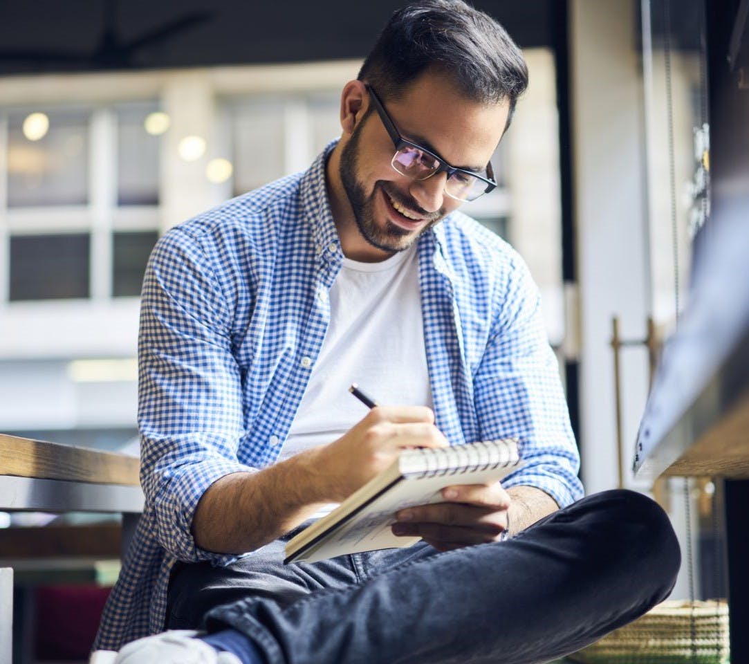 Smiling businessman working with pen and paper.