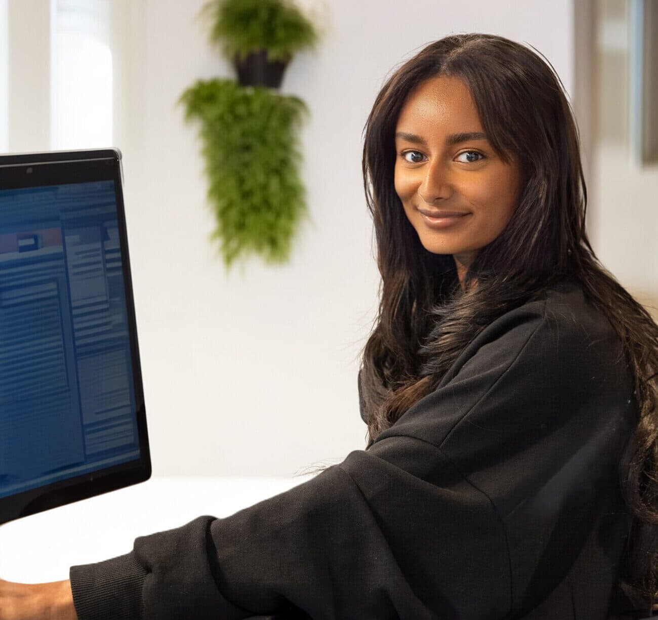 Smiling asian receptionist managing a client's diary.