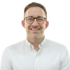 Portrait of caucasian male with glasses smiling at the camera wearing a shirt.