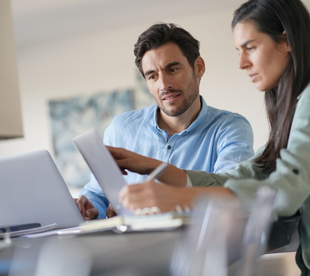 A male and a female lawyer working in a modern office with laptops.