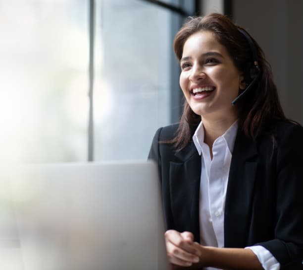 Virtual PA wearing a dark jacket with white shirt, working in an office using a VOIP helpdesk headset.